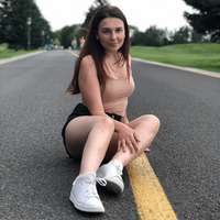 sportliche russische Frau, posiert sitzend auf der Strasse für ein Foto